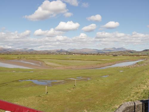 a golf course with a river and mountains in the background at Station View in Soutergate