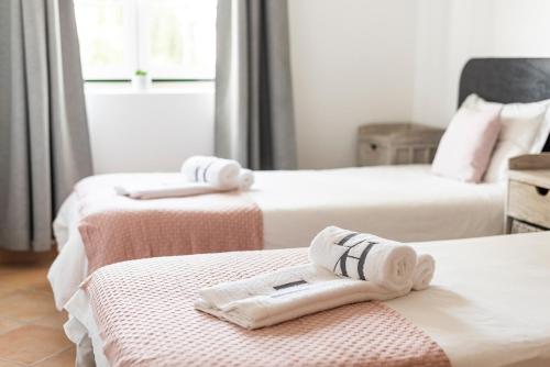 2 Betten mit Handtüchern auf einem Zimmer in der Unterkunft Old Village & Prestige in Vilamoura