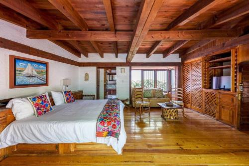 a bedroom with a large bed in a room with wooden ceilings at Agradable Hostal sobre el Centro de Valle de Bravo in Valle de Bravo