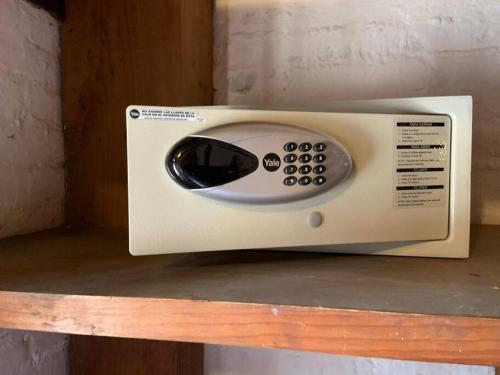 a white microwave sitting on top of a shelf at Agradable Hostal sobre el Centro de Valle de Bravo in Valle de Bravo