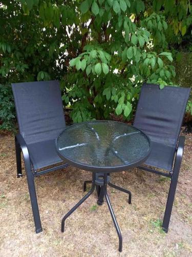 two chairs and a glass table and a table and chairs at Apartment Blattgold in Schwabach