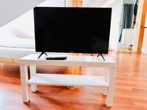 una mesa blanca con TV encima en Apartment Blattgold, en Schwabach