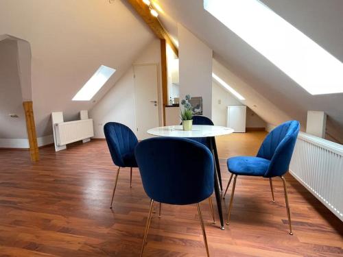 a dining room with blue chairs and a table at Apartment Blattgold in Schwabach