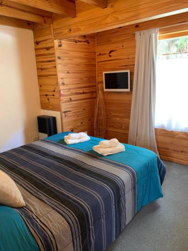 1 dormitorio con 1 cama con 2 toallas en Las Vistas en San Martín de los Andes