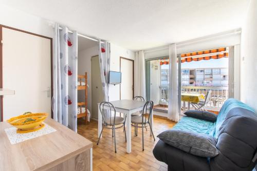 un salon avec une table et un canapé dans l'établissement La Citadelle du Soleil - 400m de la plage, au Grau-du-Roi