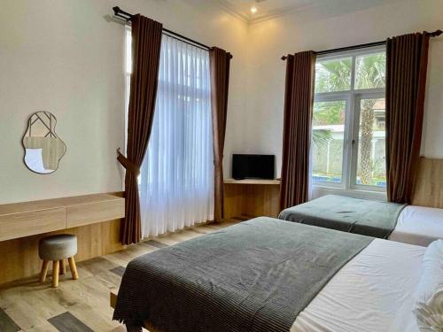 a hotel room with two beds and a window at Dhanis House 8 Bedroom Villa in Cibanawak