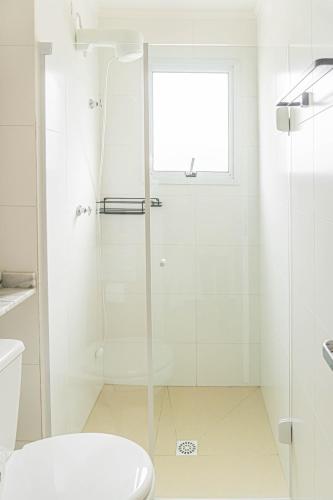 a bathroom with a shower with a toilet and a window at Cobertura Premium Hidro 3Quartos 2Vagas Ubatuba in Ubatuba