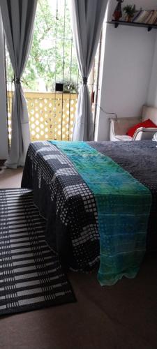 a bedroom with a bed with a black and green comforter at Quarto individual - Salvador in Salvador
