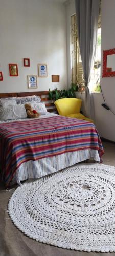 a bedroom with a bed with a rug on the floor at Quarto individual - Salvador in Salvador