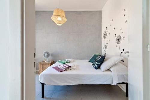 una camera da letto con letto, lenzuola e cuscini bianchi di Penthouse on the beach Gallipoli a Gallipoli