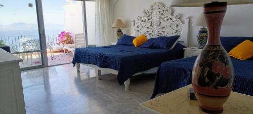 1 dormitorio con 1 cama con almohadas azules y amarillas en Hermoso condominio en Bahía Manzanillo, en Manzanillo