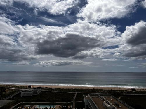 a view of the beach with a cloudy sky at Seaview, beach front, studio in Alvor