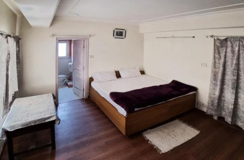 1 Schlafzimmer mit einem großen Bett und einem Badezimmer in der Unterkunft A1 B&B shimla in Shimla