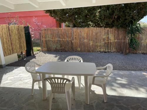 a white table and four chairs on a patio at Villa ORCHIDEA in Masainas