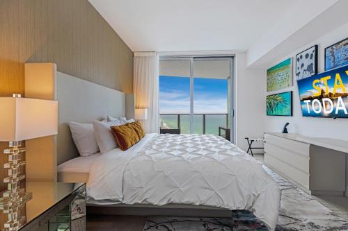 a bedroom with a bed and a large window at EXCLUSIVE RESORT - OCEANFRONT 2BD 2BA CONDO, HiGH FLOOR, ROOFTOP POOL AND HOT TUB, STEPS TO BEACH in Hollywood