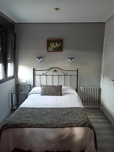 PENSION LA PARADA في Fabero: غرفة نوم بسرير كبير في غرفة