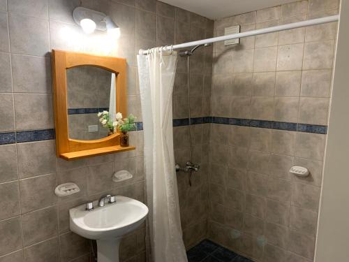 a bathroom with a sink and a shower with a mirror at Las Vistas in San Martín de los Andes