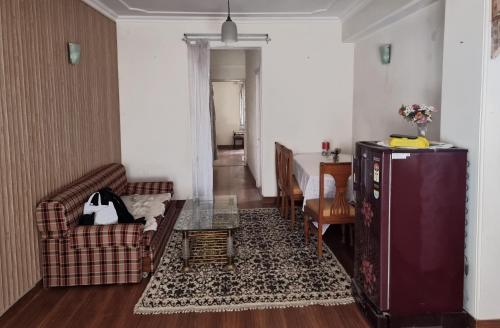 una sala de estar con un sofá y una mesa en A1 B&B shimla, en Shimla