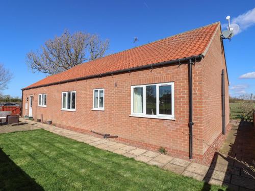 a red brick house with a grass yard at Middlegate in Ryton