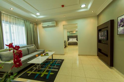 uma sala de estar com um sofá e uma mesa em Baisan Suites Al Jubail em Al Jubail