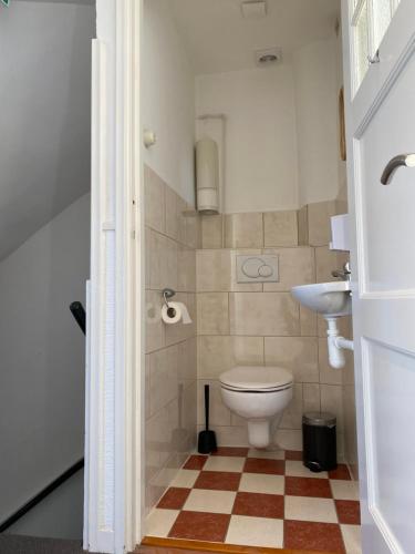 a bathroom with a toilet and a sink at Bed&Breakfast aan Strand in Katwijk aan Zee