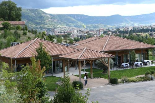 a woman walking in front of a house at Domaine Saint Estève in Millau