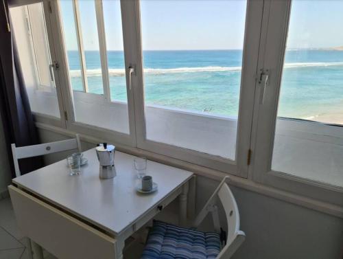 a room with a table with a view of the ocean at VV El Camarote de Playa Chica ¨by henrypole home¨ in Las Palmas de Gran Canaria
