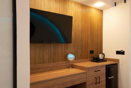 a room with a television on a wooden wall at Sartori Concept Hotel in Heraklio Town