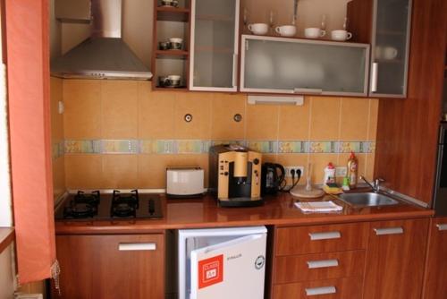 a kitchen with wooden cabinets and a white refrigerator at City Inn Residence in Timişoara