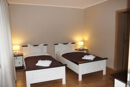 a bedroom with two white beds and two tables at City Inn Residence in Timişoara