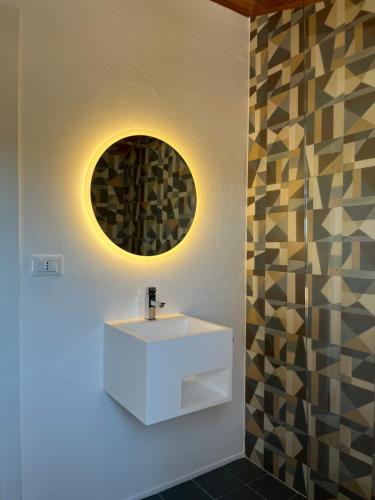 a bathroom with a white sink and a mirror at Villa Usignolo in Lignano Sabbiadoro