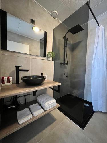 y baño con lavabo y ducha. en New modern apartment (55m2) in the city center, en Enschede