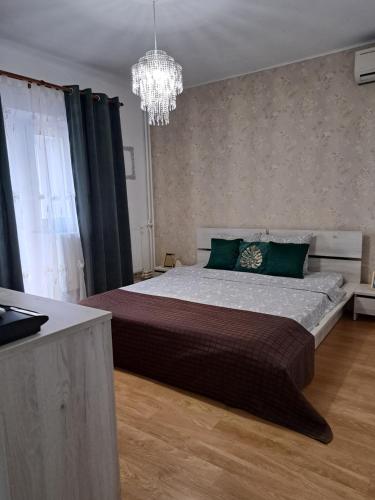 a bedroom with a large bed and a chandelier at Relax Apartament in Constanţa