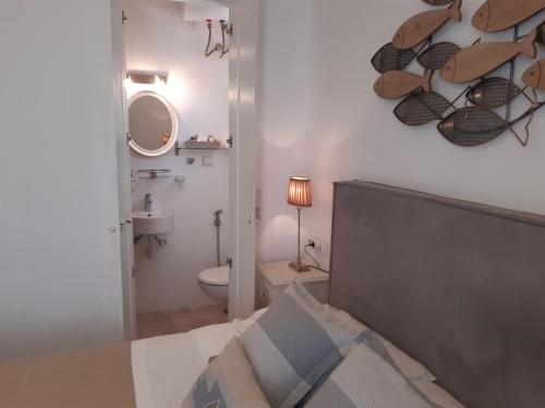 um quarto com uma cama, um WC e um espelho em Dream House em Ornos