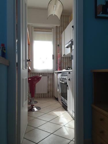 a kitchen with a window and a white tile floor at Vacanze a Finale Ligure in Finale Ligure