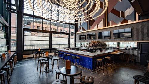 a restaurant with tables and chairs and a bar at The Rally Hotel at McGregor Square in Denver