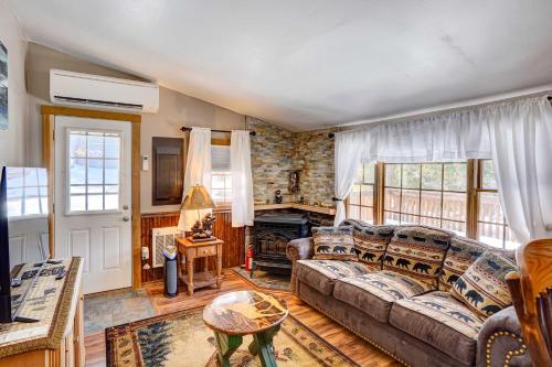 uma sala de estar com um sofá e uma lareira em Riverfront Log Cabin on the Hudson with Private Dock em Lake Luzerne