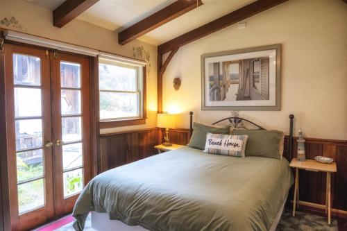 sypialnia z łóżkiem i 2 oknami w obiekcie A - Annie`s Beach House w mieście Fort Bragg