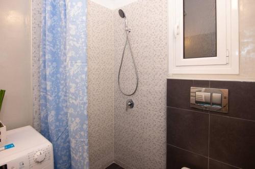 a bathroom with a shower with a blue shower curtain at 2 bedroom apartment few steps from Plaka in Athens