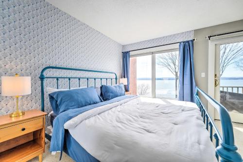 - un lit bleu dans une chambre avec fenêtre dans l'établissement Waterfront Dewittville Condo with Furnished Balcony!, à Dewittville