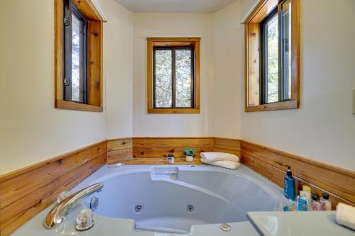 a large tub in a bathroom with two windows at Pocono Summit Vacation Rental with Grill and Fire Pits in Pocono Summit