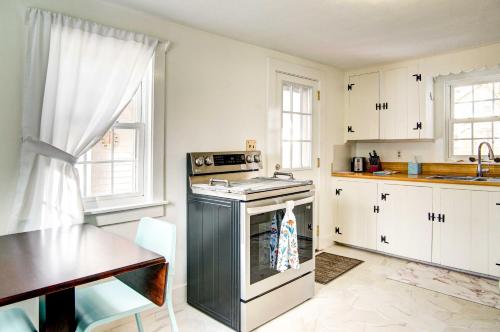 a kitchen with a stove and a sink and a table at 2 Mi to Beach Coastal Retreat in Hyannis! in Hyannis