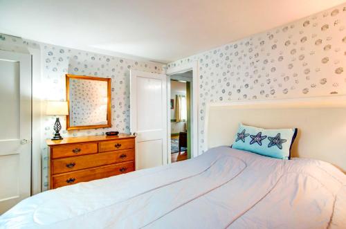 a bedroom with a bed and a dresser and a mirror at Hyannis Getaway about 2 Mi to Beach! in Hyannis