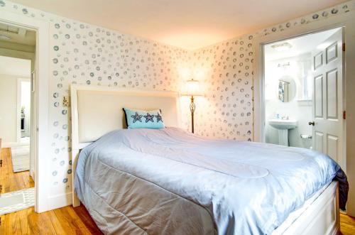 a bedroom with a large bed and a sink at 2 Mi to Beach Coastal Retreat in Hyannis! in Hyannis