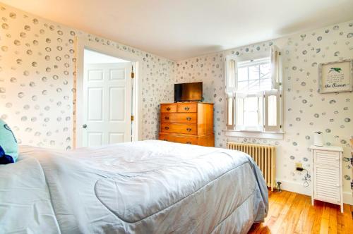a bedroom with a bed and a dresser and a window at 2 Mi to Beach Coastal Retreat in Hyannis! in Hyannis