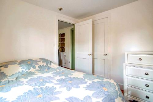 a bedroom with a bed with a blue and white blanket at 2 Mi to Beach Coastal Retreat in Hyannis! in Hyannis