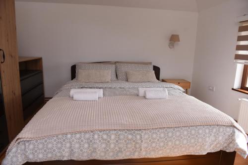 a bedroom with a large bed with two pillows at Seosko turističko domaćinstvo Kajsija in Čačak