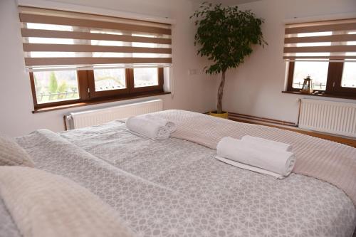 a bedroom with a large bed with two towels on it at Seosko turističko domaćinstvo Kajsija in Čačak