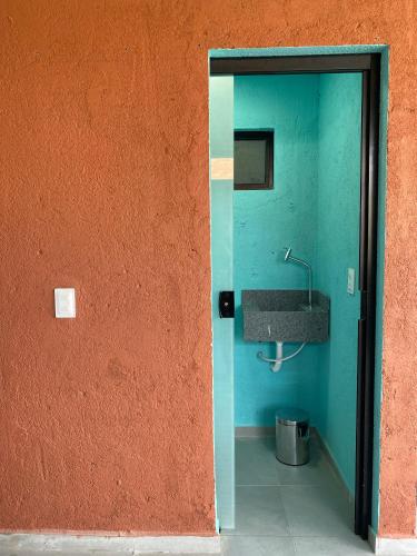 a bathroom with a sink and an orange wall at Casa de Dora in São Miguel dos Milagres