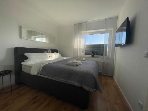 a bedroom with a large bed with a window at FeWo an der Nordseeküste I in Wilhelmshaven
